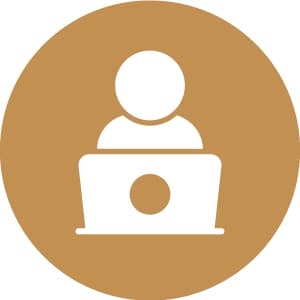 Icon of a person using a laptop, depicted in white on a brown circular background.